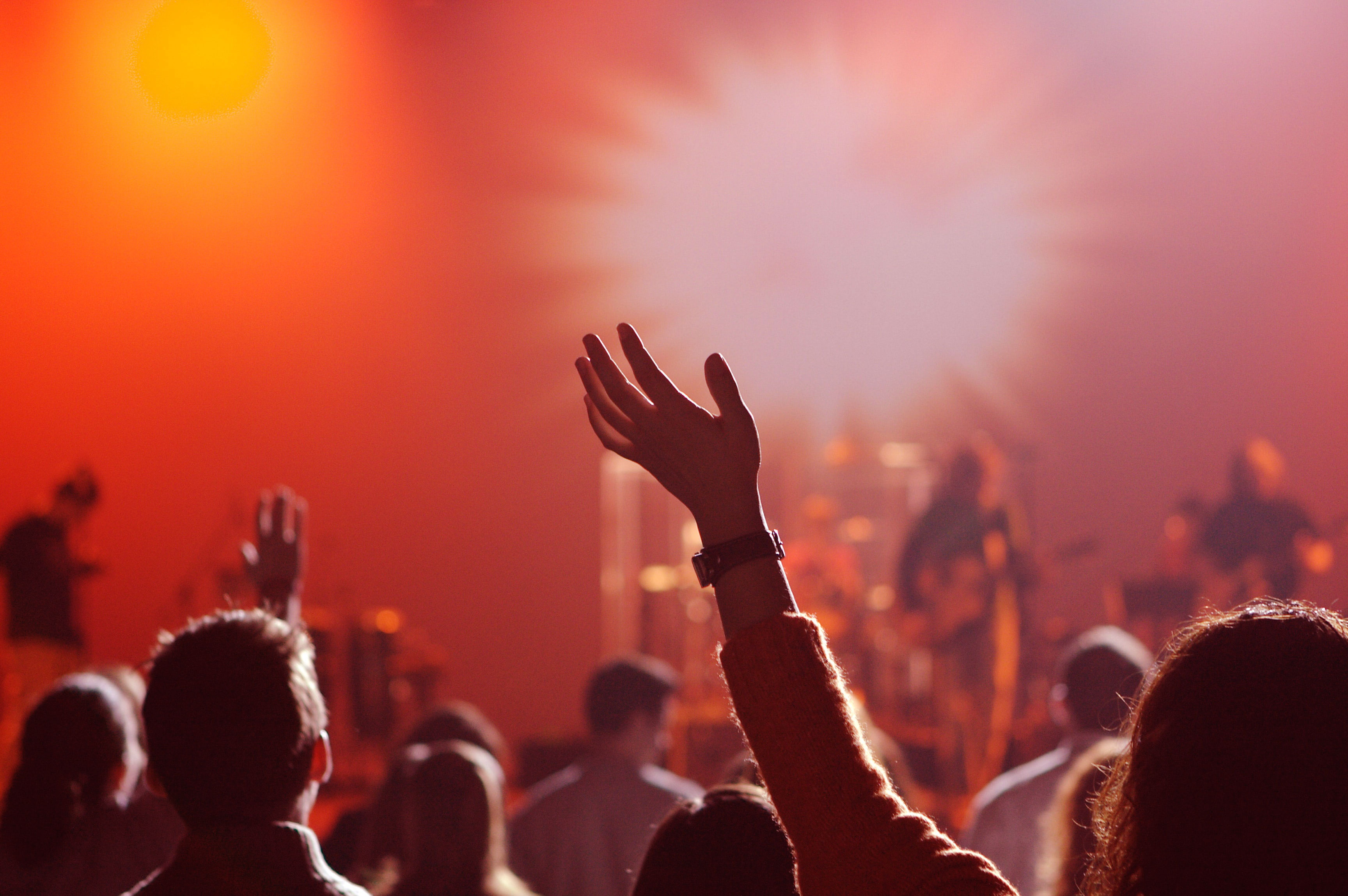 A raised hand among a worship audience